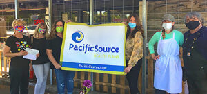A group of people holding up a sign for PacificSource